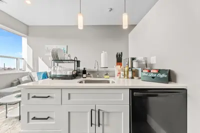 a white kitchen with a sink and a dishwasher at Modern 1 Bedroom Apartment with 2 TVs Fast WiFi and Free Parking in Cleveland