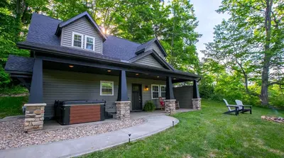 a house with a large porch with a grill at Sweet Private Cabin with Jacuzzi and Fire Pit in Ohio in Sugarcreek