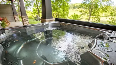 a bath tub with a sink with water in it at Sweet Private Cabin with Jacuzzi and Fire Pit in Ohio in Sugarcreek