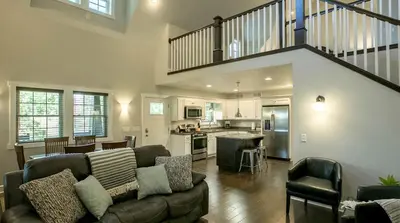 a living room with a couch and a kitchen at Sweet Private Cabin with Jacuzzi and Fire Pit in Ohio in Sugarcreek