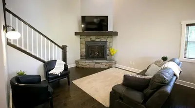 a living room with a couch and a fireplace at Sweet Private Cabin with Jacuzzi and Fire Pit in Ohio in Sugarcreek