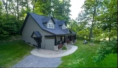 a small house with a gambrel roof at Sweet Private Cabin with Jacuzzi and Fire Pit in Ohio in Sugarcreek