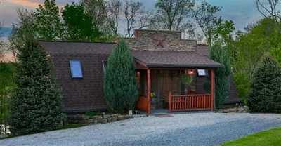 a brown house with a star on the roof at Romantic Forest Cabin with Amazing Private Deck and Spa in Ohio in Sugarcreek