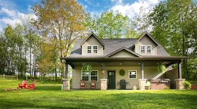 a house with a green yard with a house at Beautiful Countryside Cabin with Hot-Tub and Pond Views in Ohio in Sugarcreek