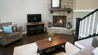 a living room with a fireplace and a television at Beautiful Countryside Cabin with Hot-Tub and Pond Views in Ohio in Sugarcreek