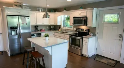 a kitchen with white cabinets and a counter top at Beautiful Countryside Cabin with Hot-Tub and Pond Views in Ohio in Sugarcreek