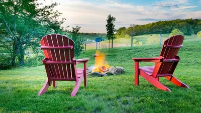 two chairs sitting next to a camp fire at Beautiful Countryside Cabin with Hot-Tub and Pond Views in Ohio in Sugarcreek