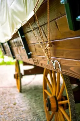 a wooden cart with yellow wheels in a field at Luxury Conestoga Wagon, Perfect for a Weekend Glamping Escape from Dayton, Ohio