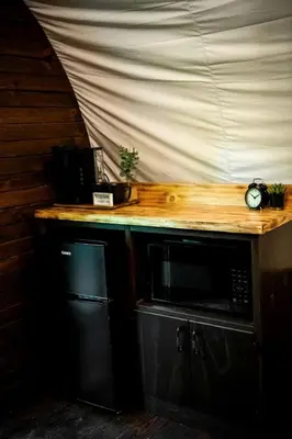 a wooden counter with a microwave on top of it at Ohio Glamping Destination in this Covered Wagon in Arcanum