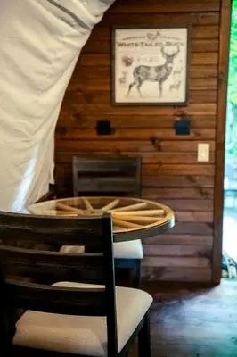 a room with a table and chairs and a picture of a cow at Ohio Glamping Destination in this Covered Wagon in Arcanum