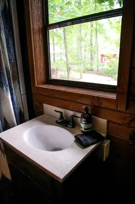 a bathroom with a sink and a window at Ohio Glamping Destination in this Covered Wagon in Arcanum