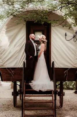 a bride and groom are standing in a doorway at Ohio Glamping Destination in this Covered Wagon in Arcanum