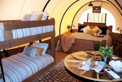 a room with two bunk beds and a table at Ohio Glamping Destination in this Covered Wagon in Arcanum
