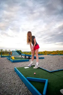 a young girl playing a game of miniature golf at Impressive Tented Cabin with Peaceful Vistas and Fire Pit in Logan, Ohio in Logan