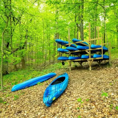 a group of kayaks sitting on the ground in the woods at Breathtaking Family Friendly Tented Cabin in Logan, Ohio in Logan