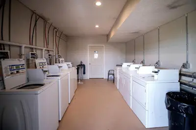 a large laundry room with white washers and dryers at Breathtaking Family Friendly Tented Cabin in Logan, Ohio in Logan