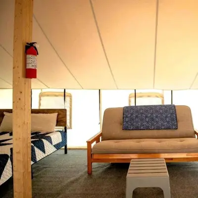 a living room with a couch and a canopy at Sensational Tented Cabin Nestled Amidst Trees and Fire Pit Provided in Logan, Ohio in Logan