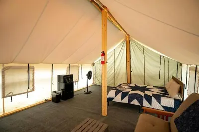a bedroom with a bed in a tent at Beautiful Tented Cabin Nestled Amidst Trees with Incredible Hiking Trails Near in Logan, Ohio in Logan