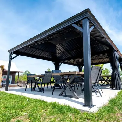 a picnic table and chairs under a black pavilion at Charming Tented Cabin Placed in a Selcuded Area in Logan, Ohio in Logan