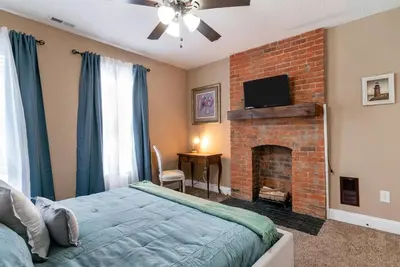 a bedroom with a bed and a brick fireplace at 4 Bedroom Luxe home in Brewery District in Columbus
