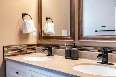 a bathroom with two sinks and two mirrors at 4 Bedroom Luxe home in Brewery District in Columbus