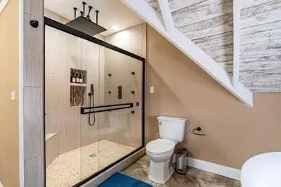 a bathroom with a toilet and a glass shower at 4 Bedroom Luxe home in Brewery District in Columbus