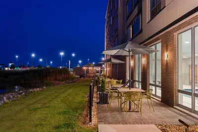 a patio with tables and chairs and an umbrella at Hampton Inn & Suites By Hilton Port Clinton Catawba Island in Port Clinton