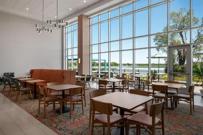 a dining room with tables and chairs and large windows at Hampton Inn & Suites By Hilton Port Clinton Catawba Island in Port Clinton
