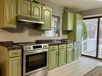 a kitchen with green cabinets and an oven at Retreat on Lake Milton in Berlin Center