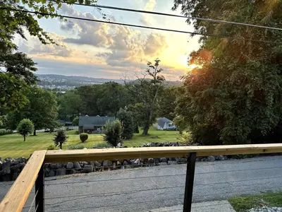 a view from the porch of a house with the sunset at Scandanavian Cottage with a View in Canonsburg
