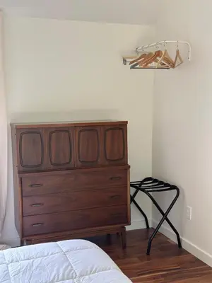 a bedroom with a wooden dresser next to a bed at Scandanavian Cottage with a View in Canonsburg