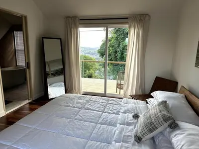 a bedroom with a large bed and a large window at Scandanavian Cottage with a View in Canonsburg