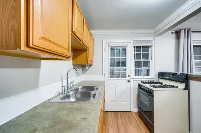a kitchen with a sink and a stove at 2 Mi to Lake Erie Home with Yard in Euclid! in Euclid