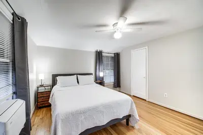 a white bedroom with a bed and a ceiling fan at 2 Mi to Lake Erie Home with Yard in Euclid! in Euclid