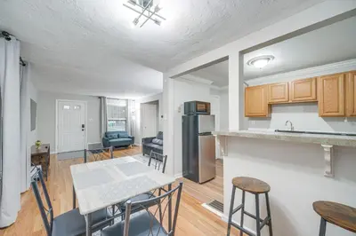 a kitchen and living room with a table and chairs at 2 Mi to Lake Erie Home with Yard in Euclid! in Euclid