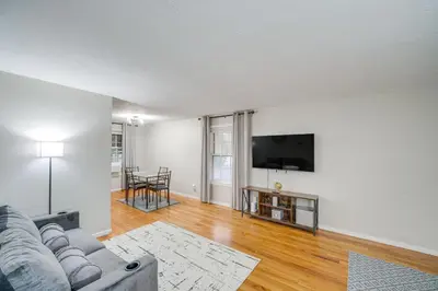 a living room with a couch and a flat screen tv at 2 Mi to Lake Erie Home with Yard in Euclid! in Euclid