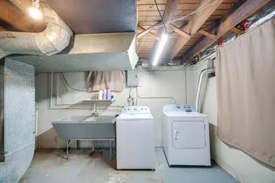 a bathroom with a sink and a washing machine at 2 Mi to Lake Erie Home with Yard in Euclid! in Euclid