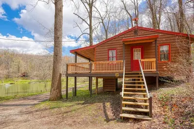 a cabin in the woods with a staircase leading up to it at Wyandot Woods - Lake House in Laurelville