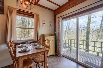 a dining room with a table and a large window at Wyandot Woods - Cedar House in Laurelville