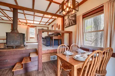 a dining room with a table and a wood stove at Wyandot Woods - Cedar House in Laurelville