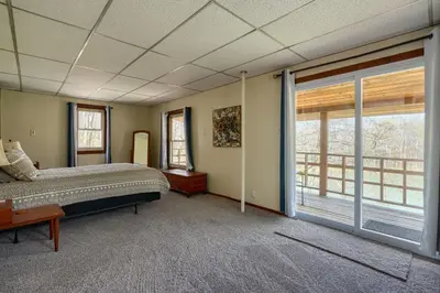 a bedroom with a bed and a large window at Wyandot Woods - Cedar House in Laurelville