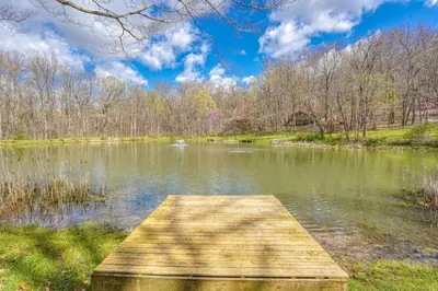 a wooden dock in the middle of a lake at Wyandot Woods - Cedar House in Laurelville