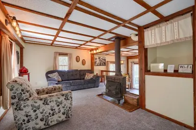 a living room with a couch and a wood stove at Wyandot Woods - Cedar House in Laurelville