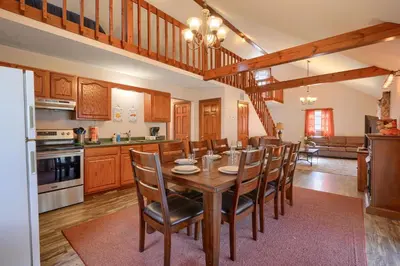 a kitchen and dining room with a wooden table and chairs at Wyandot Woods - Hillside in Laurelville