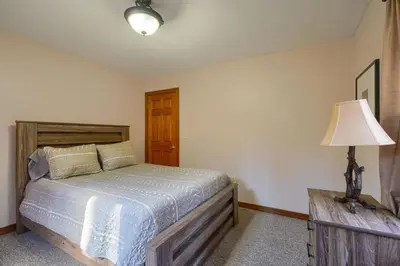 a bedroom with a wooden bed and a lamp at Wyandot Woods - Hillside in Laurelville