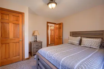 a bedroom with a bed and a wooden door at Wyandot Woods - Hillside in Laurelville