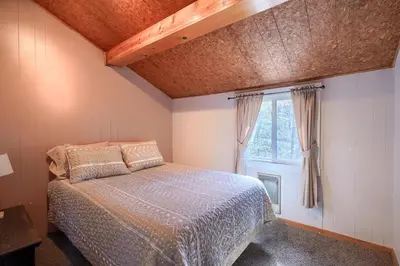 a bedroom with a bed and a window at Wyandot Woods - Squirrels Nest in Laurelville