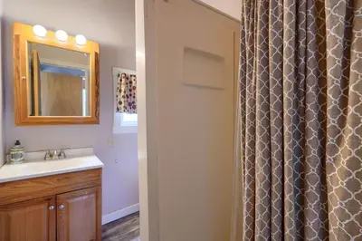 a bathroom with a sink and a shower curtain at Wyandot Woods - Squirrels Nest in Laurelville