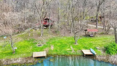 a group of benches sitting next to a pond at Wyandot Woods - Squirrels Nest in Laurelville