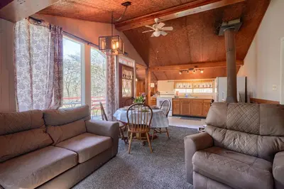 a living room with a couch and a table at Wyandot Woods - Squirrels Nest in Laurelville